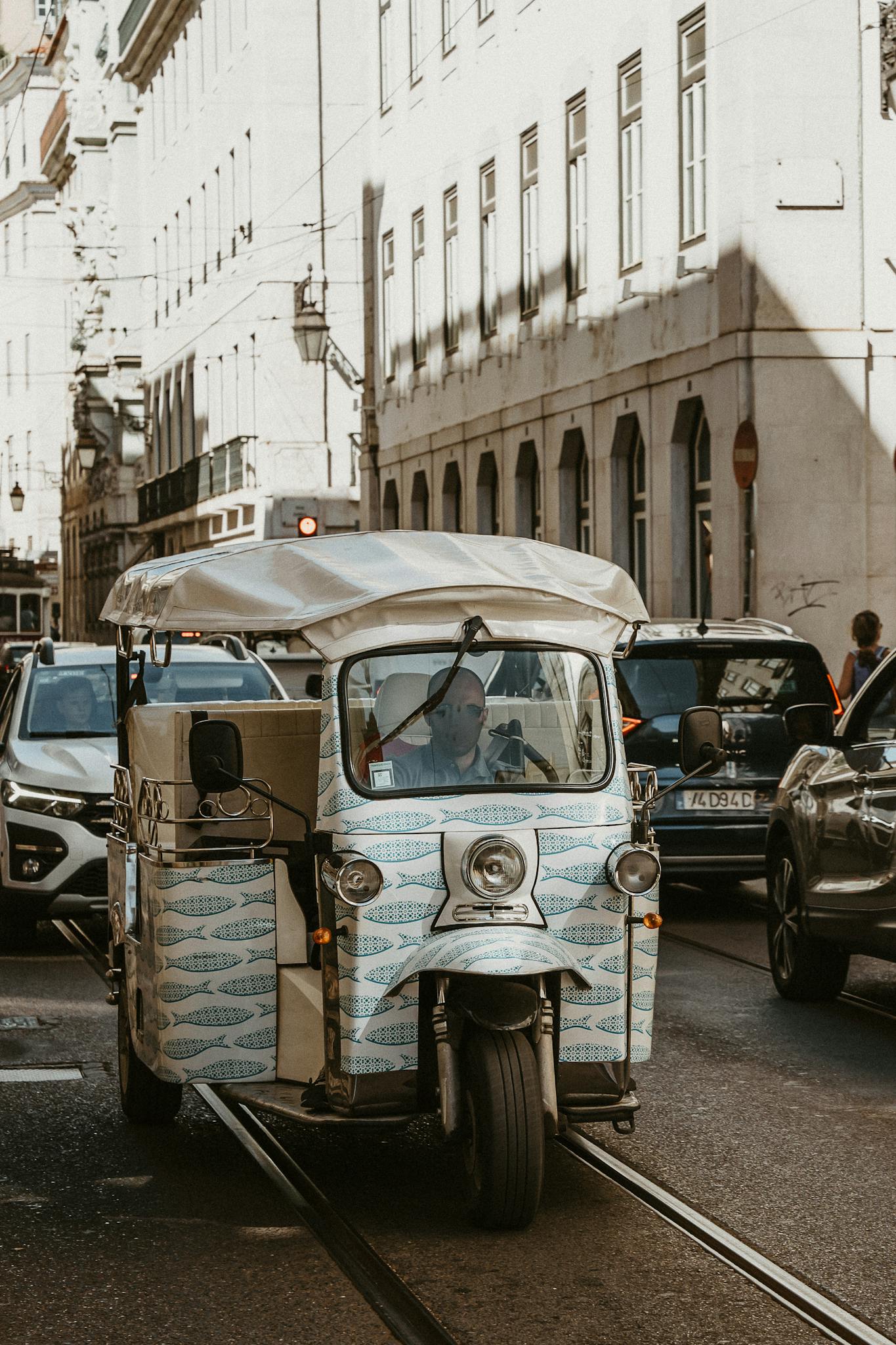 A vintage tuk-tuk navigating the busy streets of Lisbon in summer. Captures the essence of urban tourism.