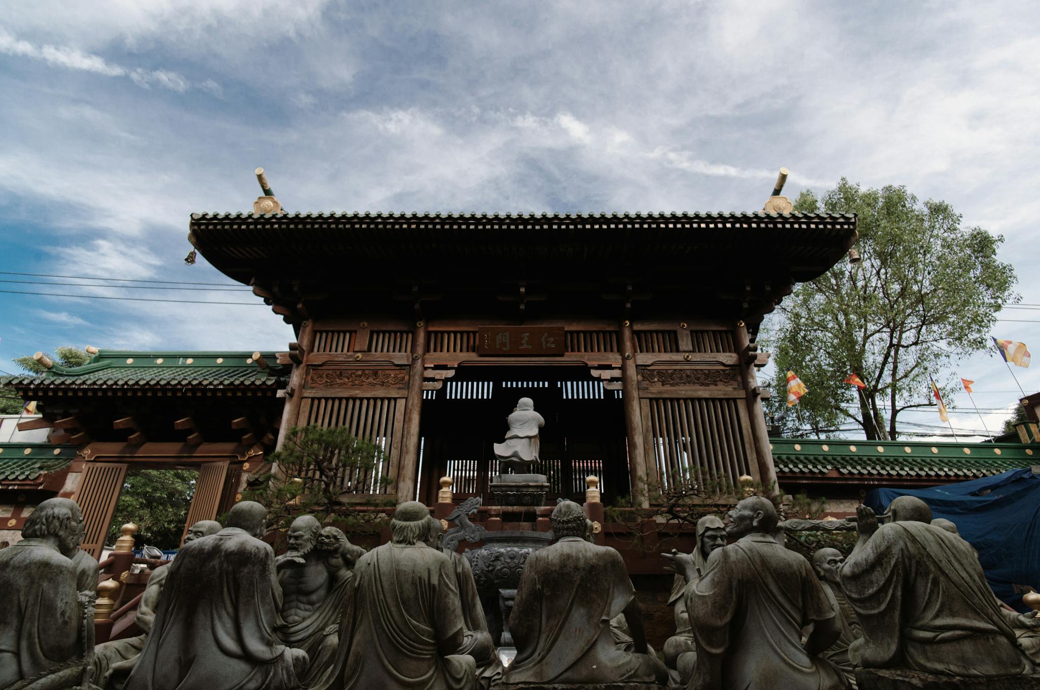 Intricate temple architecture surrounded by stone statues under a clear blue sky, perfect for travel enthusiasts.